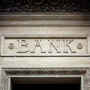 Old bank sign engraved in stone or concrete above the door of financial building concept for finance and business